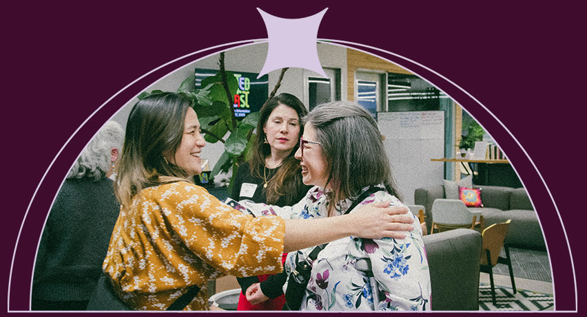 A woman placing a hand on another woman's shoulder in a show of support