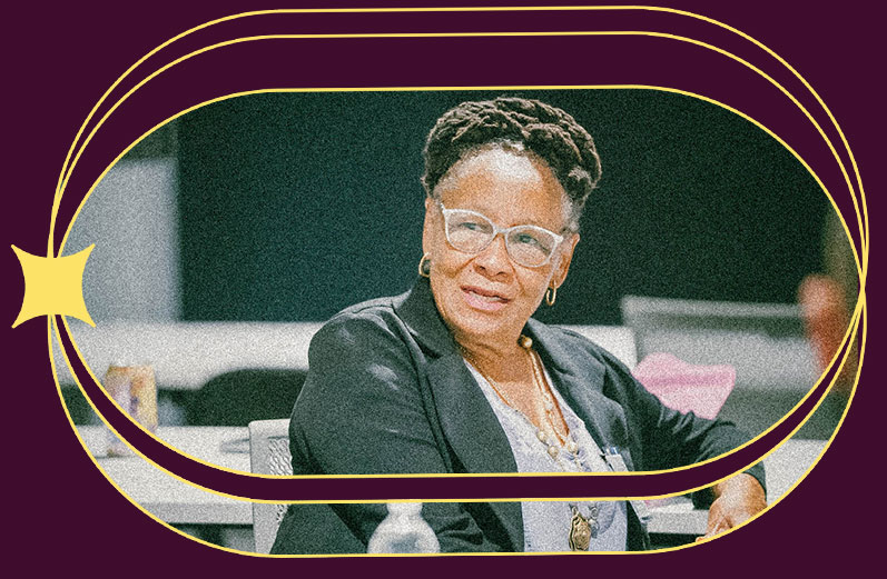 An older woman speaks at a conference table